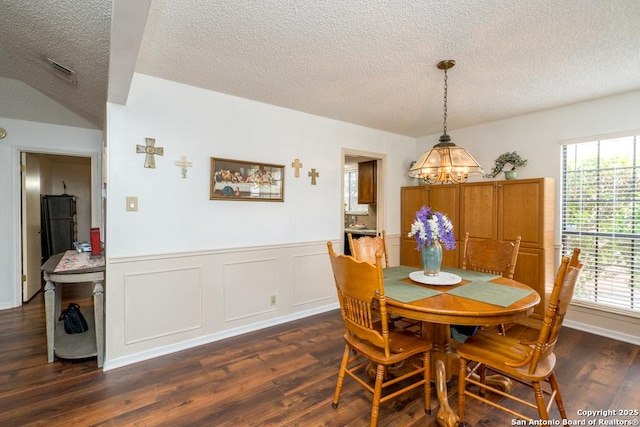 5823 Archwood, San Antonio, TX 78239 - dining space featuring a chandelier, a textured ceiling, healthy amount of natural light, dark wood-type flooring, and a wainscoted wall