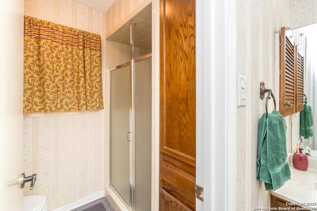 5823 Archwood, San Antonio, TX 78239 - full bathroom featuring wallpapered walls, a stall shower, and toilet