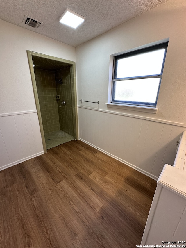 6127 Walking Gait, San Antonio, TX 78240 - full bath with wood finished floors, a tile shower, wainscoting, and a textured ceiling