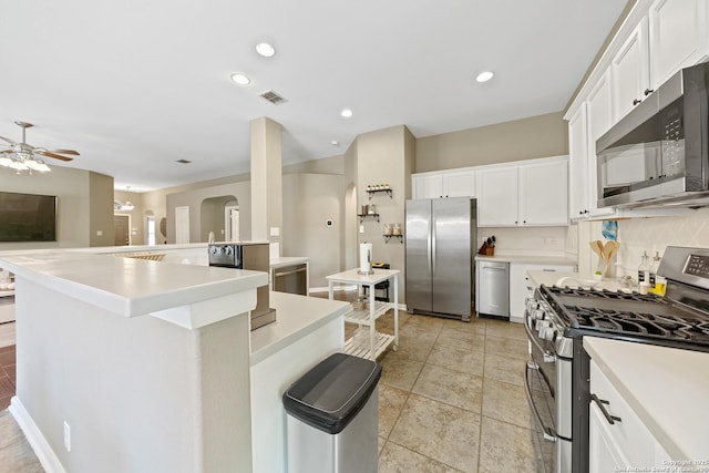 13014 Essen, Helotes, TX 78023 - kitchen with stainless steel appliances, decorative backsplash, arched walkways, a ceiling fan, and light countertops
