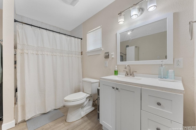 8608 S Foster Rd, San Antonio, TX 78222 - full bath featuring toilet, vanity, wood finished floors, and curtained shower