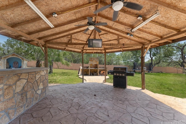 8608 S Foster Rd, San Antonio, TX 78222 - view of patio featuring a fireplace, a gazebo, a ceiling fan, a trampoline, and area for grilling
