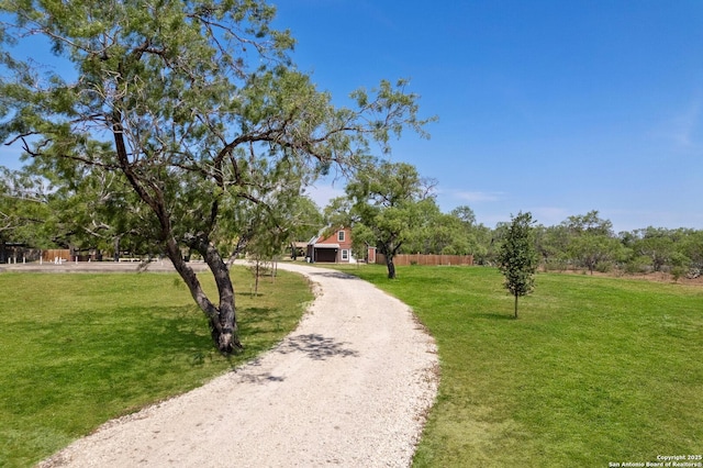 8608 S Foster Rd, San Antonio, TX 78222 - view of home's community with a lawn, curved driveway, and an outdoor structure
