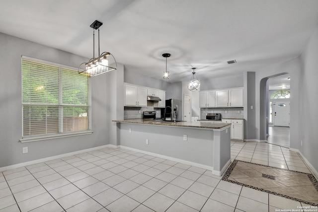 1947 Walter Raleigh, Windcrest, TX 78239 - kitchen with light tile patterned flooring, arched walkways, stainless steel fridge with ice dispenser, and healthy amount of natural light