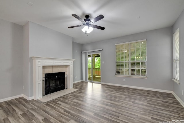 1947 Walter Raleigh, Windcrest, TX 78239 - unfurnished living room featuring light wood-style flooring, a tiled fireplace, ceiling fan, and baseboards