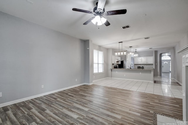 1947 Walter Raleigh, Windcrest, TX 78239 - unfurnished living room with ceiling fan, light wood finished floors, baseboards, and a sink