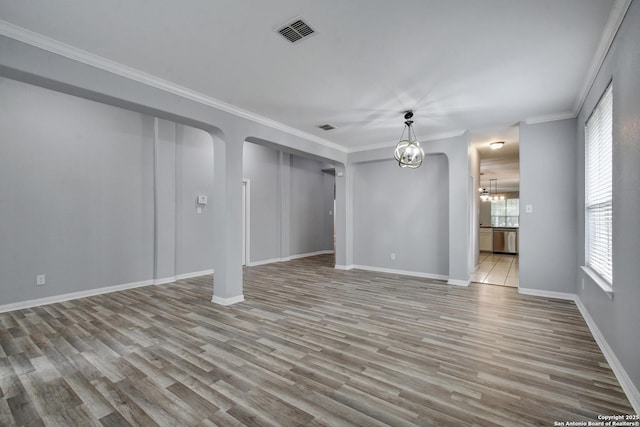 1947 Walter Raleigh, Windcrest, TX 78239 - unfurnished living room featuring a chandelier, wood finished floors, baseboards, ornamental molding, and arched walkways