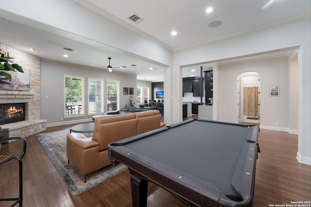 314 Regent Cir, Shavano Park, TX 78231 - game room with a stone fireplace, ornamental molding, dark wood-type flooring, arched walkways, and ceiling fan