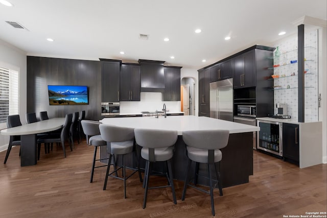314 Regent Cir, Shavano Park, TX 78231 - kitchen with built in refrigerator, wine cooler, ornamental molding, a kitchen breakfast bar, and a kitchen island with sink