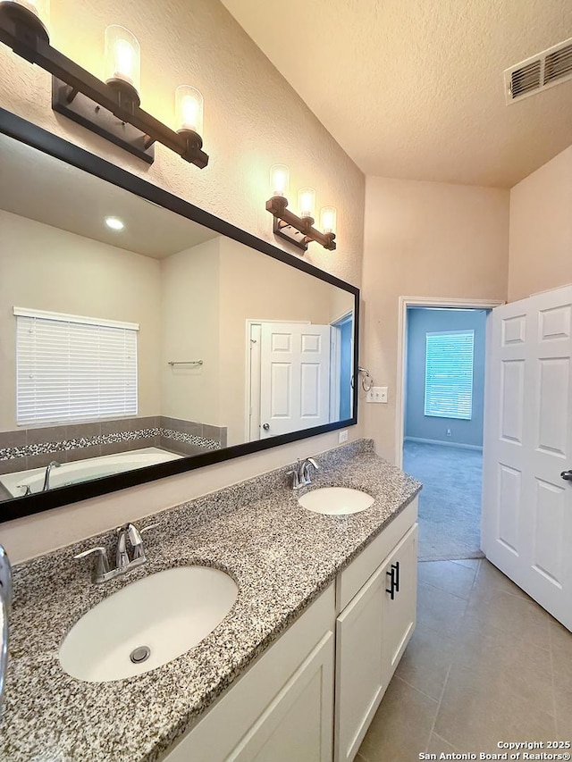 2035 Tillman Park, San Antonio, TX 78253 - full bath with double vanity, a textured ceiling, tile patterned flooring, and a bath