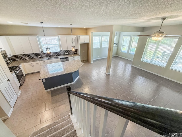 2035 Tillman Park, San Antonio, TX 78253 - kitchen with gas range, plenty of natural light, backsplash, dishwasher, and a textured ceiling