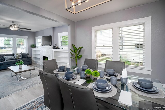 128 Blanco, San Antonio, TX 78212 - dining area with wood finished floors, a ceiling fan, and a brick fireplace