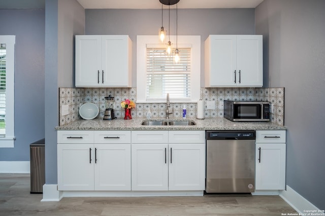 128 Blanco, San Antonio, TX 78212 - kitchen with stainless steel appliances, a sink, backsplash, light stone counters, and light wood finished floors