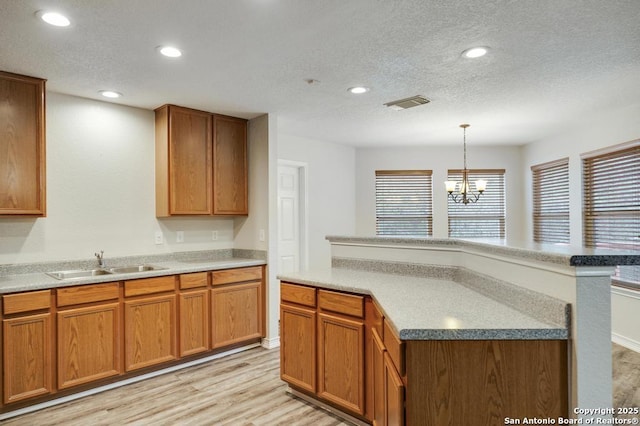 17214 Irongate Rail, San Antonio, TX 78247 - kitchen featuring a sink, light wood-type flooring, a textured ceiling, a chandelier, and recessed lighting