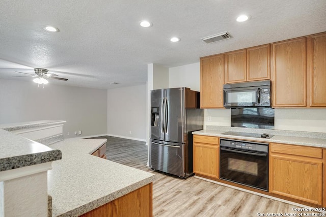 17214 Irongate Rail, San Antonio, TX 78247 - kitchen with black appliances, a textured ceiling, light wood-type flooring, light countertops, and recessed lighting