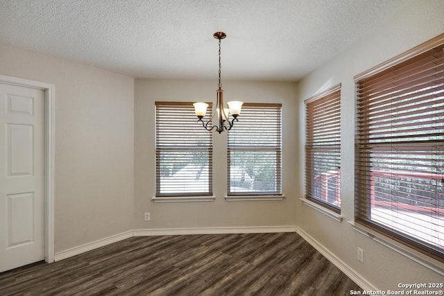 17214 Irongate Rail, San Antonio, TX 78247 - unfurnished dining area with a chandelier, dark wood-type flooring, a textured ceiling, and baseboards