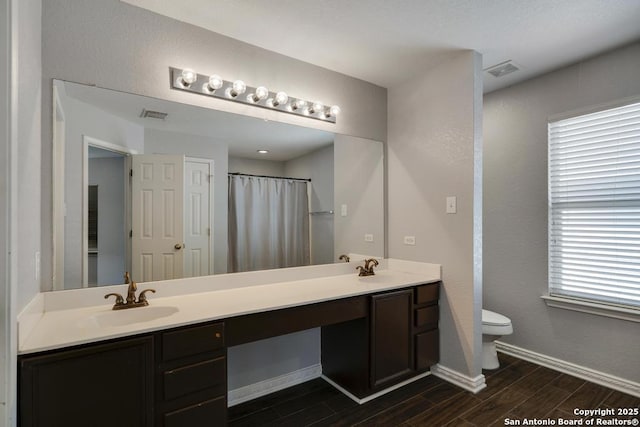 17214 Irongate Rail, San Antonio, TX 78247 - full bath with wood finish floors, double vanity, toilet, and baseboards