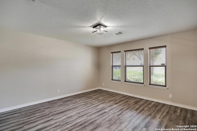 17214 Irongate Rail, San Antonio, TX 78247 - empty room featuring dark wood finished floors, a textured ceiling, and baseboards