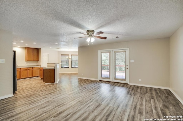 17214 Irongate Rail, San Antonio, TX 78247 - unfurnished living room with light wood-style floors, ceiling fan, baseboards, a textured ceiling, and recessed lighting