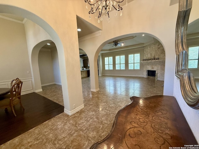 1410 Melanie, San Antonio, TX 78258 - unfurnished living room with arched walkways, plenty of natural light, crown molding, a fireplace, and a ceiling fan