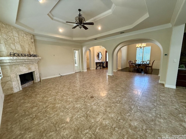 1410 Melanie, San Antonio, TX 78258 - unfurnished living room featuring a tray ceiling, arched walkways, ceiling fan, ornamental molding, and a fireplace