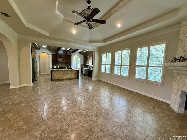 1410 Melanie, San Antonio, TX 78258 - unfurnished living room with arched walkways, ceiling fan, a raised ceiling, crown molding, and a fireplace