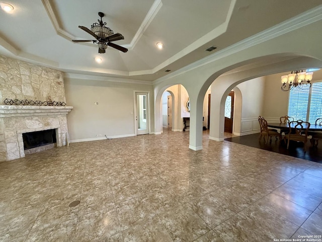 1410 Melanie, San Antonio, TX 78258 - unfurnished living room with a tray ceiling, a ceiling fan, crown molding, a fireplace, and arched walkways