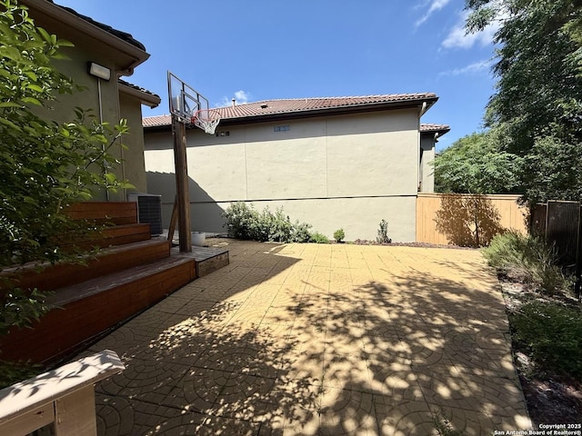 1410 Melanie, San Antonio, TX 78258 - view of side of property featuring stucco siding, central AC, a tile roof, and a patio