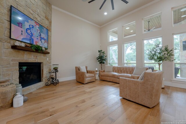 507 Arthur Ct, Spring Branch, TX 78070 - living room featuring a ceiling fan, a towering ceiling, ornamental molding, wood finished floors, and a stone fireplace