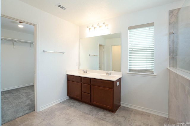 2006 Prometheus Cv, San Antonio, TX 78245 - full bath with double vanity, a walk in closet, baseboards, and a tile shower