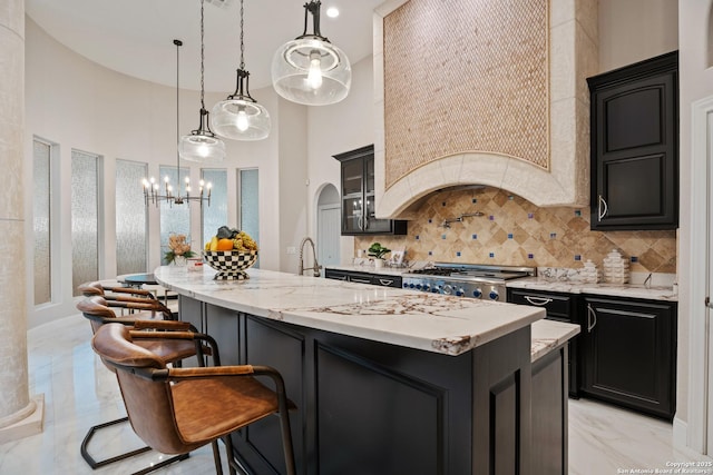 3 Benchwood Cir, San Antonio, TX 78248 - kitchen with light marble finish floors, tasteful backsplash, a towering ceiling, dark cabinetry, and exhaust hood