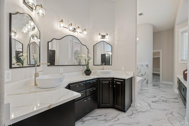 3 Benchwood Cir, San Antonio, TX 78248 - full bathroom featuring double vanity, marble look tiles, a freestanding tub, and a walk in closet