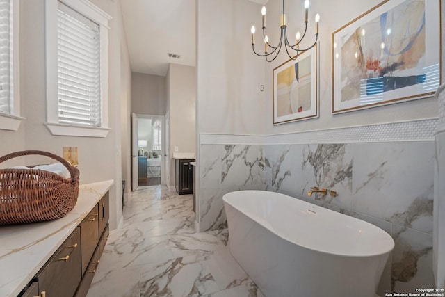 3 Benchwood Cir, San Antonio, TX 78248 - full bath featuring a freestanding bath, marble finish flooring, wainscoting, tile walls, and a chandelier
