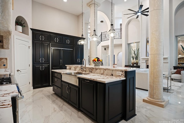 3 Benchwood Cir, San Antonio, TX 78248 - kitchen featuring ornate columns, a towering ceiling, light marble finish flooring, and dark cabinetry