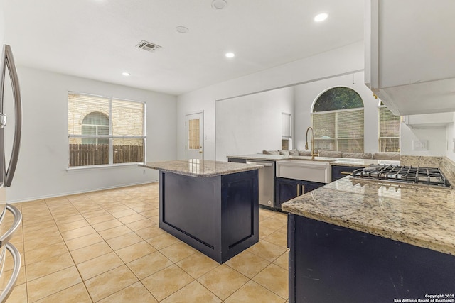 6218 Ozona Ml, San Antonio, TX 78253 - kitchen with appliances with stainless steel finishes, a sink, a center island, light tile patterned floors, and light stone countertops