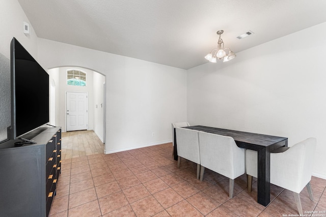 7619 Bit Cir, Elmendorf, TX 78112 - unfurnished dining area with a chandelier, arched walkways, baseboards, and light tile patterned flooring