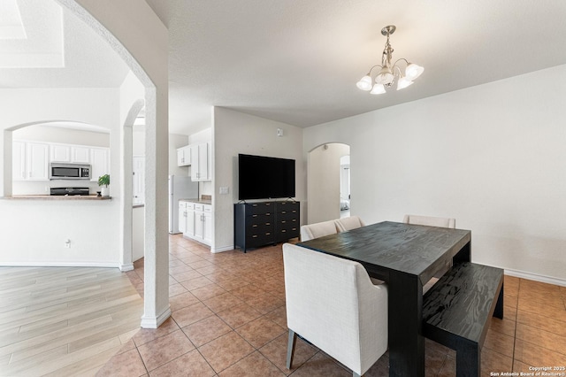 7619 Bit Cir, Elmendorf, TX 78112 - dining area with arched walkways, a chandelier, baseboards, and light tile patterned floors