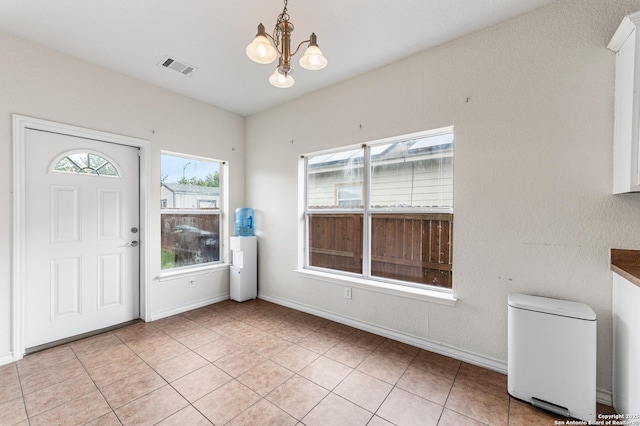7619 Bit Cir, Elmendorf, TX 78112 - foyer entrance with a chandelier, baseboards, and light tile patterned floors