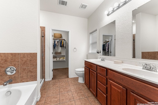 7619 Bit Cir, Elmendorf, TX 78112 - bathroom with a spacious closet, double vanity, a bath, a stall shower, and tile patterned floors