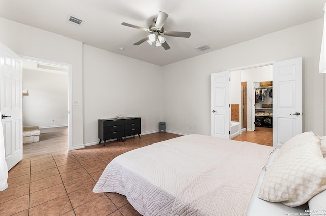 7619 Bit Cir, Elmendorf, TX 78112 - bedroom with light tile patterned floors, a spacious closet, a ceiling fan, baseboards, and a closet