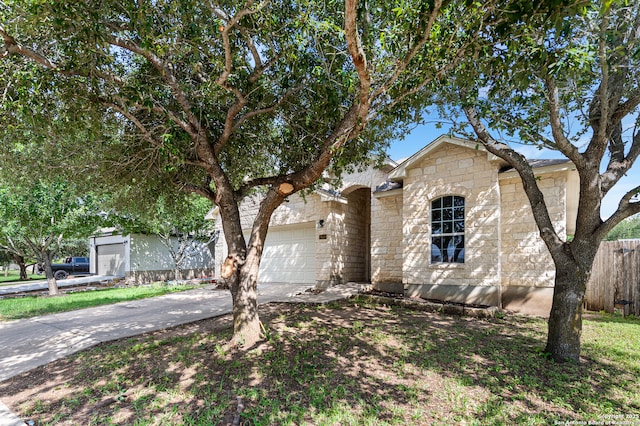 7619 Bit Cir, Elmendorf, TX 78112 - view of front of home with an attached garage, stone siding, and concrete driveway