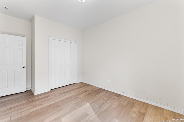 7619 Bit Cir, Elmendorf, TX 78112 - unfurnished bedroom with light wood-style floors, a closet, and baseboards