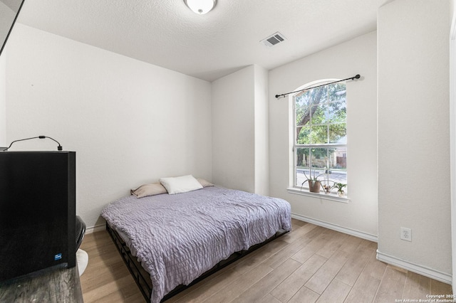 7619 Bit Cir, Elmendorf, TX 78112 - bedroom with light wood-style floors and baseboards