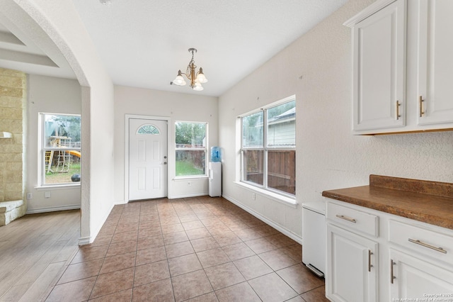 7619 Bit Cir, Elmendorf, TX 78112 - unfurnished dining area with a chandelier, arched walkways, and baseboards