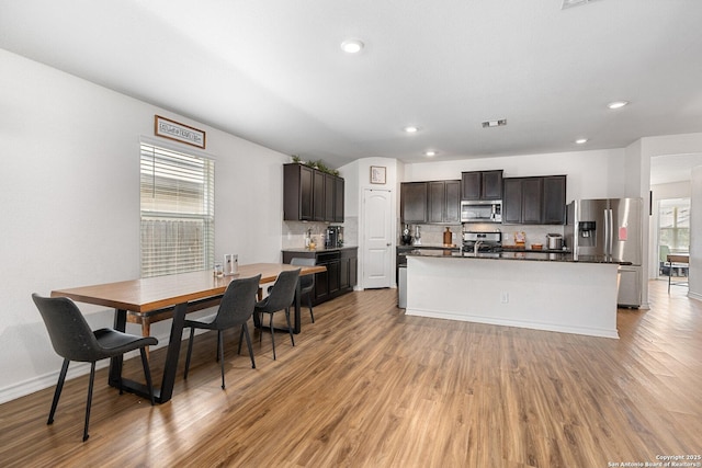 6417 Hoffman Pln, San Antonio, TX 78252 - kitchen with appliances with stainless steel finishes, backsplash, light wood-style flooring, dark countertops, and recessed lighting