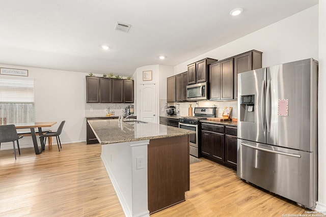 6417 Hoffman Pln, San Antonio, TX 78252 - kitchen with stainless steel appliances, a sink, dark brown cabinetry, light wood finished floors, and recessed lighting