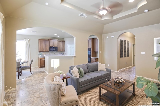 8022 Grissom Crst, San Antonio, TX 78251 - living room featuring ceiling fan, arched walkways, light tile patterned flooring, a tray ceiling, and recessed lighting
