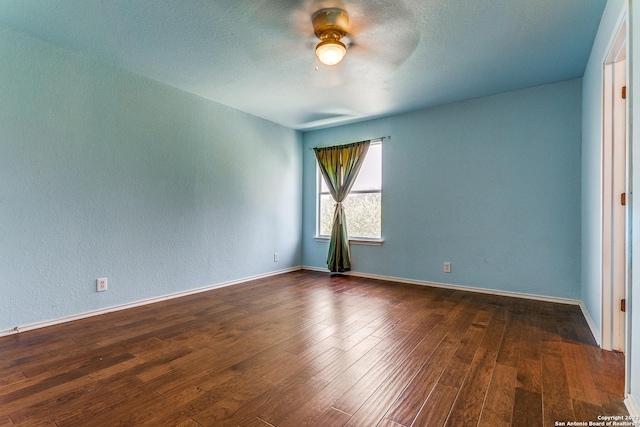 8227 Maloy Mnr, San Antonio, TX 78250 - empty room with a ceiling fan, dark wood-style flooring, a textured wall, and baseboards