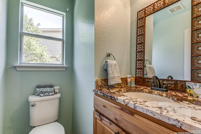 8227 Maloy Mnr, San Antonio, TX 78250 - bathroom featuring vanity, toilet, and a textured wall