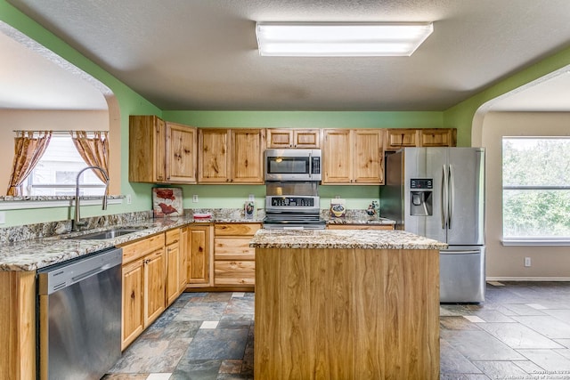 8227 Maloy Mnr, San Antonio, TX 78250 - kitchen with stainless steel appliances, a sink, stone tile flooring, and arched walkways
